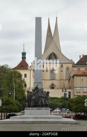 Denkmal der tschechoslowakischen Legionen nach dem Entwurf des tschechischen Bildhauers Josef Mařatka (1932) in Nové Město (Neustadt) in Prag, Tschechische Republik. Das Kloster Emmaus (Emauzský klášter) ist im Hintergrund zu sehen. Die Klosterkirche wurde durch den Bombenangriff der USA am 14. Februar 1945 schwer beschädigt. Die neue modernistische Fassade des tschechischen Architekten František Maria Černý wurde zwischen 1964 und 1968 erbaut. Stockfoto