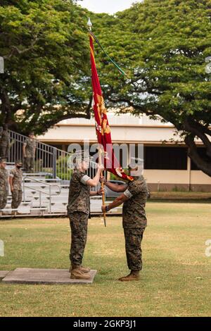 US Marine Corps LT. Col. Carrie C. Batson, links, ausscheidender Kommandant, Hauptquartier-Bataillon, Marine Corps Base Hawaii, erhält die organisatorischen Farben von Sgt. Maj. Jose Romero, Hauptfeldwebel, HQBN, während der HQBN-Befehlswechselzeremonie, 10. Juni 2021. Batson gab das Kommando an Oberstleutnant Stephen M. McNeil ab. Stockfoto