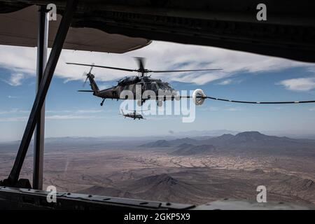 Ein US Air Force HH-60G Pave Hawk erhält Treibstoff von einem HC-130J Combat King II über Arizona, 10. Juni 2021. Der HC-130J, der von James Corless, dem Maj der US-Luftwaffe, gesteuert wurde, betankte zwei HH-60G Pave Hawks, von denen einer von seiner Gattin, Maj. Heather Corless, pilotiert wurde. Stockfoto