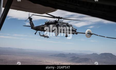 Ein US Air Force HH-60G Pave Hawk erhält Treibstoff von einem HC-130J Combat King II über Arizona, 10. Juni 2021. Der HC-130J, der von James Corless, dem Maj der US-Luftwaffe, gesteuert wurde, betankte zwei HH-60G Pave Hawks, von denen einer von seiner Gattin, Maj. Heather Corless, pilotiert wurde. Stockfoto