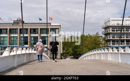 Le Havre, Frankreich - 8. August 2021: Zwei Migrantinnen überqueren die Fußgängerbrücke über das Commerce Basin in Le Havre Stockfoto