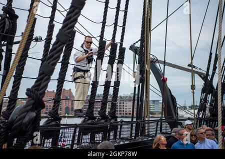 BOSTON (11. Juni 2021) Master-at-Arms der 1. Klasse Travis Hagerty aus Gilbert, Arizona, klettert während einer Feier an Bord der USS Constitution die Schutzhüllen hoch. USS Constitution, das älteste in Auftrag gegebene Kriegsschiff der Welt, spielte eine entscheidende Rolle in den Barbarenkriegen und dem Krieg von 1812 und verteidigte von 1797 bis 1855 aktiv die Seewege. Während des normalen Betriebs bieten die an Bord der USS Constitution stationierten aktiven Seeleute kostenlose Touren an und bieten mehr als 600,000 Menschen pro Jahr öffentliche Besichtigungen an, da sie die Mission des Schiffes unterstützen, die Beförderung zu fördern Stockfoto