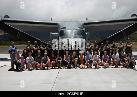 U.S. Marinesoldaten mit Marine Medium Tiltrotor Squadron 268 und Marine Heavy Helicopter Squadron 463, Pose mit einer lokalen Mädchengruppe während einer statischen Ausstellung, Marine Corps Training Area Bellows, 11. Juni 2021. Der Zweck der statischen Darstellung ist es, die Öffentlichkeit für das Marine Corps zu sensibilisieren und zu verstehen. Stockfoto