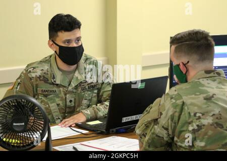 SPC der US-Armee. Jace Santana (links), Personalmanager des 143. Sustainment Command (Expeditionary), stellt sicher, dass die Formulare während einer Soldier Readiness Processing-Veranstaltung am 11. Juni 2021 in Decatur, Georgia, korrekt sind. Stockfoto