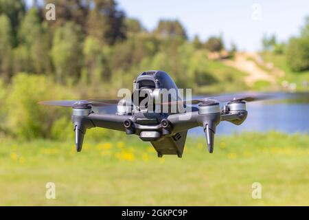 Moskau, 31. MAI 2021 : Eine neue DJI FPV-Drohne fliegt an einem sonnigen Tag auf Gras im Beckground. Vorderansicht Von Oben. Headless Quadcopter mit Digital 4K 60 Stockfoto