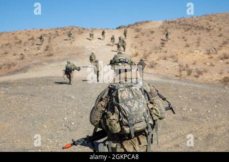 Soldaten des 1. Bataillons, 297. Infanterie-Regiment, Wyoming Army National Guard, kommen während einer Trainingsübung im National Training Center, Fort Irwin, Kalifornien, am 12. Juni 2021 zu einem Ziel vor. Die Teilnahme des 1-297.s an der NTC-Rotation ermöglicht es dem 155. Kampfteam der Panzerbrigade, der Nationalgarde der Mississippi-Armee und unterstützenden Einheiten, Teamarbeit aufzubauen und die Kampfbereitschaft für zukünftige Missionen aufrechtzuerhalten. Stockfoto