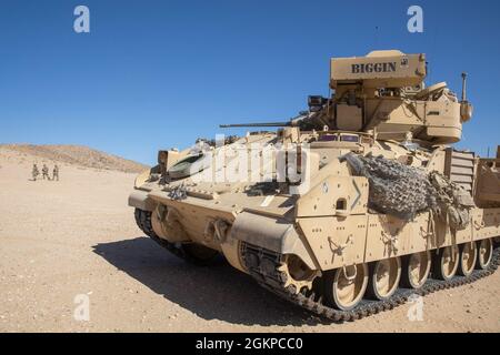 Ein Kampffahrzeug M2A2 Bradley, das dem 1. Bataillon, dem 155. Infanterie-Regiment der Mississippi Army National Guard, zugewiesen wurde, bietet Sicherheit für Soldaten, die während eines Angriffstrainings im National Training Center, Fort Irwin, Kalifornien, am 12. Juni 2021 zu einem Ziel vorrücken. Die 1-155., als Teil des 155. Kampfteams der Panzerbrigade, führt im NTC eine Schulung durch, um die Bereitschaft bei zukünftigen Missionen zu unterstützen. Stockfoto