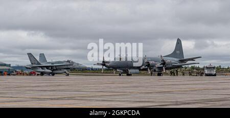 Royal Canadian Air Force F-18 Hornet von 433 Tactical Fighter Squadron, 3 Wing, Bagotville, und Royal Canadian Air Force CP-140 Aurora, von 405 Long Range Patrol Squadron, 14 Wing, Greenwood, nehmen an NORAD-Übung Teil Amalgam Dart, 12. Juni 2021, 5 Wing, Goose Bay, Neufundland und Labrador. Übung Amalgam Dart wird vom 10. Bis 18. Juni 2021 laufen, wobei die Operationen in der gesamten Arktis von der Beaufort-See bis nach Thule, Grönland, reichen. Amalgam Dart 21-01 bietet NORAD die Möglichkeit, die kontinentalen Verteidigungsfähigkeiten zu verbessern, während kanadische und US-Streitkräfte in der Arktis zusammenarbeiten. Ein bi-nationaler Stockfoto