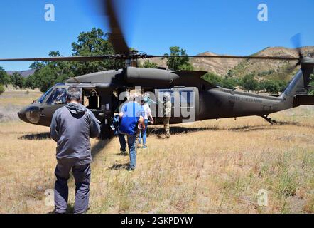 Calif. Army National Guard UH-60L bringt die Unterstützung der Vertreter der Wache und Reserve und der Boss Lift Arbeitgeber von der C-130 des 129. Luftrettungsflügels auf dem Paso Robles Airport nach Fort Hunter Liggett, Kalifornien, 12. Juni 2021. Während des Besuchs der FHL werden die zivilen Arbeitgeber über die Aufgaben informiert, die Soldaten und Luftmänner bei der Verteidigung der Nation leisten. Stockfoto