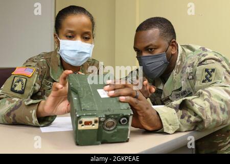 Von links: U.S. Army SPC. Nanyamka A. Salley, ein Personalspezialist, und Maj. Brandon McCalla, der Signaloffizier, üben die Programmierung eines Radios während einer Kommunikationsklasse für Mitglieder der 642. Regionalen Unterstützungsgruppe im Army Reserve Center in Decatur, Georgia. Das Training hilft den Truppen, die Kommunikation auf dem Feld aufrechtzuerhalten. Stockfoto