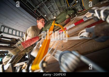 Ein Mitglied des 153. Luftlift-Flügels, Wyoming Air National Guard, hilft beim Transport von Fracht auf ein C-130 Hercules-Flugzeug zum Training am 13. Juni 2021 Cheyenne, Wyo. Die C-130 kann eine Vielzahl von übergroßen Ladungen aufnehmen, Darunter alles, von Utility-Hubschraubern und sechsrädrigen gepanzerten Fahrzeugen bis hin zu Standard-palettierter Ladung und Militärpersonal. Stockfoto