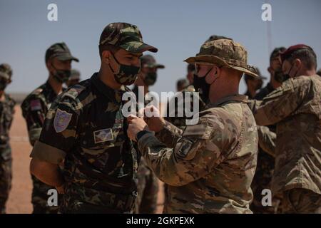 Ein Fallschirmjäger der US-Armee, der dem 2. Bataillon, dem 503. Infanterie-Regiment, der 17. Luftbrigade, zugewiesen wurde, überreicht einem Fallschirmjäger der Royal Moroccan Army während eines Flügelwechsels auf dem Luftwaffenstützpunkt Grier Labouie in Marokko am 13. Juni 2021 das Abzeichen der US-Armee für den Fallschirmjäger. Africa Lion 21 begann mit US- und marokkanischen Fallschirmjägern, die einen Luftsprung nach Marokko durchführten. African Lion 2021 ist die größte, führende, gemeinsame, jährliche Übung des US-Afrikanischen Kommandos, die vom 7-18. Bis 22. Juni von Marokko, Tunesien und Senegal veranstaltet wird. Mehr als 7,000 Teilnehmer aus neun Nationen und der NATO trainieren gemeinsam mit dem Fokus auf die Verbesserung der Bereitschaft Stockfoto