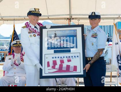 Capt. Holly Harrison (links) wird während einer Befehlswechselzeremonie auf der Coast Guard Base Honolulu, 14. Juni 2021, von Ashley LaBarr (rechts), dem leitenden Chief Petty Officer, die Kommissionierkutter Kimball, überreicht. Während der Zeremonie entlastete Capt. Thomas D’Arcy Capt. Holly Harrison während des hinteren ADM. Peter Gautier, stellvertretender Kommandant der Küstenwache im pazifischen Raum, präsidierte. Stockfoto