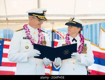 Hinterer Adm. Peter Gautier, stellvertretender Kommandant der Küstenwache im pazifischen Raum, überreicht Capt. Holly Harrison während einer Zeremonie zur Änderung des Kommandos auf der Küstenwache in Honolulu, 14. Juni, 2021. Während der Befehlswechselzeremonie wurde Harrisons kommandierender Offizier des Küstenwachtschneiderei Kimball von Kapitän Thomas D'Arcy entlastet. Stockfoto