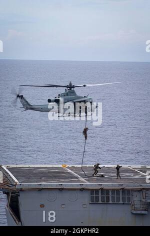 US-Marineinfanteristen mit dem Force Reconnaissance Platoon, 31. Marine Expeditionary Unit (MEU), Schnellseil eines UH-1Y Venom Hubschraubers zur Durchführung einer Trainingsübung für eine maritime Interdiction Operation (Mio) im Ostchinesischen Meer, 14. Juni 2021. Die MIO bestand aus Force Reconnaissance Marines, die schnell zur USS New Orleans (CA-31) aufsuchten und ein Such- und Beschlagnahmungsszenario ausführte. Die 31. MEU ist an Bord von Schiffen der America Amphibious Ready Group im Einsatzgebiet der 7. Flotte tätig, um die Interoperabilität mit Verbündeten und Partnern zu verbessern und als einsatzbereite Einsatztruppe zur Verteidigung von Frieden und s zu dienen Stockfoto