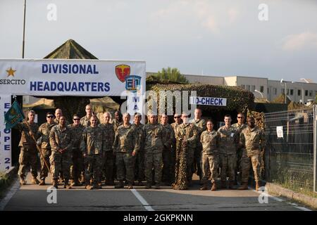 Soldaten der 2500. Digital Liaison Detachment, des 7. Mission Support Command und des 44. Expeditionary Signal Bataillons, der 2. Signal Brigade, sowie Evaluatoren der Southern European Task Force der US Army – Afrika, Pose gemeinsam vor dem Divisionszentrum der italienischen Armee´s Divisione Acqui beim Abschluss einer Kommandoübung für DEFENDER-Europe 21 in Capua, Italien, 14. Juni 2021. Die 2500. DLD bot Verbindungsfähigkeit zwischen dem US Army´s V Corps und der Divisione Acqui der italienischen Armee. Stockfoto