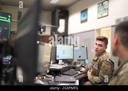 US Air Force Staff Sgt. Hovhannes Balian, Senior Board Controller des 18. Maintenance Group Maintenance Operations Center, diskutiert die Betriebsplanung auf dem Luftwaffenstützpunkt Kadena, Japan, 14. Juni 2021. Das 18. MOC unterstützt direkt die von Kadena zugewiesenen Flugzeuge einschließlich der Marine, des Marine Corps und der transienten Flugzeuge. Stockfoto