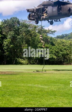 Ein Mitglied der Costa-ricanischen Polizei forciert schnelle Seile aus einem Hubschrauber der US-Armee UH-60 Blackhawk, der dem 1. Bataillon, 228. Aviation Regiment, Joint Task Force-Bravo, Soto Cano Air Base, Honduras, während des Fast-Rope Insertion and Extraction System (FRIES) Trainings in Liberia, Costa Rica, 15. Juni 2021, zugewiesen wurde. Das System wird in Situationen eingesetzt, in denen das Gelände ein Flugzeug von der Landung abhält und die Servicemitarbeiter schnell zum Ziel gelangen müssen. Stockfoto