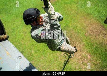 Ein Mitglied der Costa-ricanischen Polizei forciert schnelle Seile aus einem Hubschrauber der US-Armee UH-60 Blackhawk, der dem 1. Bataillon, 228. Aviation Regiment, Joint Task Force-Bravo, Soto Cano Air Base, Honduras, während des Fast-Rope Insertion and Extraction System (FRIES) Trainings in Liberia, Costa Rica, 15. Juni 2021, zugewiesen wurde. Das System wird in Situationen eingesetzt, in denen das Gelände ein Flugzeug von der Landung abhält und die Servicemitarbeiter schnell zum Ziel gelangen müssen. Stockfoto