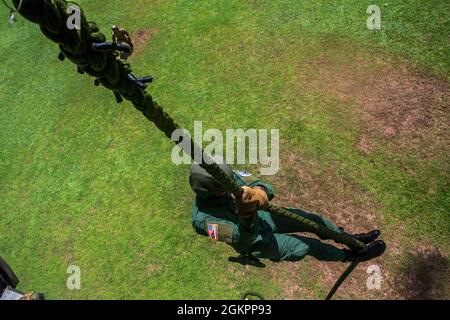 Ein Mitglied der Costa-ricanischen Polizei forciert schnelle Seile aus einem Hubschrauber der US-Armee UH-60 Blackhawk, der dem 1. Bataillon, 228. Aviation Regiment, Joint Task Force-Bravo, Soto Cano Air Base, Honduras, während des Fast-Rope Insertion and Extraction System (FRIES) Trainings in Liberia, Costa Rica, 15. Juni 2021, zugewiesen wurde. Das System wird in Situationen eingesetzt, in denen das Gelände ein Flugzeug von der Landung abhält und die Servicemitarbeiter schnell zum Ziel gelangen müssen. Stockfoto