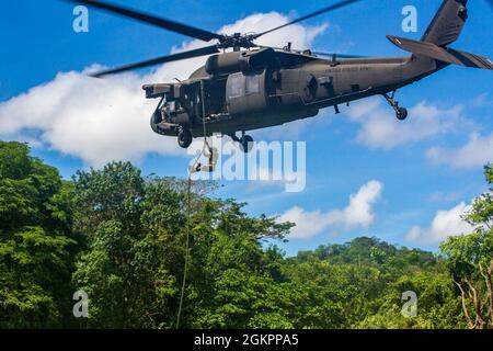 Ein Mitglied der Costa-ricanischen Polizei forciert schnelle Seile aus einem Hubschrauber der US-Armee UH-60 Blackhawk, der dem 1. Bataillon, 228. Aviation Regiment, Joint Task Force-Bravo, Soto Cano Air Base, Honduras, während des Fast-Rope Insertion and Extraction System (FRIES) Trainings in Liberia, Costa Rica, 15. Juni 2021, zugewiesen wurde. Das System wird in Situationen eingesetzt, in denen das Gelände ein Flugzeug von der Landung abhält und die Servicemitarbeiter schnell zum Ziel gelangen müssen. Stockfoto