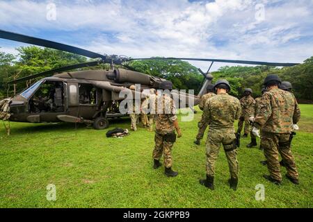 Soldaten der US-Armee, die dem 1. Bataillon, dem 228. Luftwaffenregiment, der Joint Task Force-Bravo, dem Soto Cano Air Base, Honduras, und Polizisten der Costa-ricanischen Polizei zugewiesen wurden, hören sich vor der Durchführung einer Schulung zum schnellen Einstecken und Extraktionssystem (FRIESE) in Liberia, Costa Rica, 15. Juni 2021 eine Sicherheitsunterweisung an. Die Ausbildung von Besatzungen im 1-228. Luftfahrtregiment ermöglicht es der Task Force, eine Vielzahl von Missionen mit größerer Flexibilität und Kompetenz zu unterstützen. Stockfoto