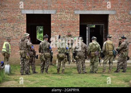 Observer Coach Trainer im Combat Training Center führen eine Nachbesprechung mit ukrainischen Soldaten durch, die der 95. Luftangriff-Brigade im Internationalen Friedens- und Sicherheitszentrum in der Nähe von Yavoriv, Ukraine, zugewiesen sind, 15. Juni 2021. Ausbildung zur Durchführung von Militäroperationen im städtischen Gelände wird die 95. Brigade als Teil der Joint Multinary Training Group-Ukraine in die Ukraine entsandt, einer internationalen Koalition, die sich der Verbesserung der Ausbildungskapazität des CTC und dem Aufbau von Professionalität innerhalb der ukrainischen Armee widmet. Stockfoto