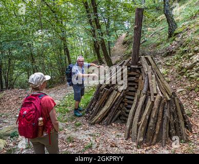 Unterwegs mit dem Wanderführer Luca Goldhorn im UNESCO-Weltkulturerbe Maggia-Tal. Hier zeigt er den Querschnitt eines Kohlestapels, Circolo della Maggia, Schweiz Stockfoto