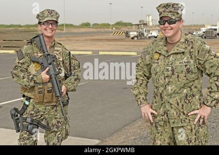 CAMP LEMONNIER, Dschibuti (15. Juni 2021) US-Navy Master-at-Arms der 1. Klasse Caitlin Sullivan, rechts, aus Louisville, Ky., und Master-at Arms der 1. Klasse Sheana McAnerny aus Strawberry, Arizona, die beide an das Sicherheitsministerium von Camp Lemonnier angeschlossen sind, stehen auf der Fluglinie von Camp Lemonnier zusammen. Das Camp Lemonnier liegt strategisch günstig in Dschibuti, in der Nähe der Bab al-Mandab-Straße, am südlichen Ende des Roten Meeres. Camp Lemonnier hilft US-amerikanischen, alliierten und Partnernationskräften, die Sicherheit in Europa, Afrika und Südwestasien aufrechtzuerhalten. Stockfoto