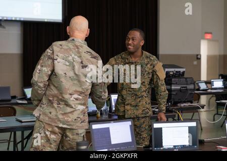 Generalmajor James O. Eifert, der Adjutant General von Florida, interagiert mit einem Mitglied der Royal Bahamas Defence Force während einer Cyber-Übung in St. Augustine, Florida, am Mittwoch, 16. Juni 2021. Tradewinds 2021 ist eine vom U.S. Southern Command geförderte, auf Sicherheit ausgerichtete karibische Übung im Bereich Boden, Luft, Meer und Internet, die mit Partnerländern zusammenarbeitet, um gemeinsame, kombinierte und interbehördliche Schulungen durchzuführen, die sich auf die Verbesserung der regionalen Zusammenarbeit und Stabilität konzentrieren. Stockfoto