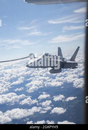 Eine finnische Luftwaffe F/A-18C Hornet mit Jagdgeschwader 31 betankt von einer KC-130J Super Hercules mit Marine Aerial Refueller und Transport Squadron (VMGR) 452 während der Luftbefüllung über dem Luftwaffenstützpunkt Rissala, in der Nähe von Kuopio, Finnland, am 8. Juni 2021. Marines mit VMGR-452 werden nach Kuopio, Finnland, zur Unterstützung von Squadron Visit ILVES (Finnisch für „Lynx“) eingesetzt. Das Ziel von Squadron Visit ILVES ist es, Luft-Luft- und Luft-Boden-Schulungen durchzuführen, die Kompetenz in gemeinsamen und multinationalen Taktiken zu verbessern und Partnerschaften mit internationalen Verbündeten zu stärken. Stockfoto