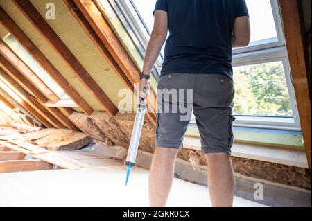 Handwerker verschließen ein neues Fenster auf dem Dachboden. Stockfoto