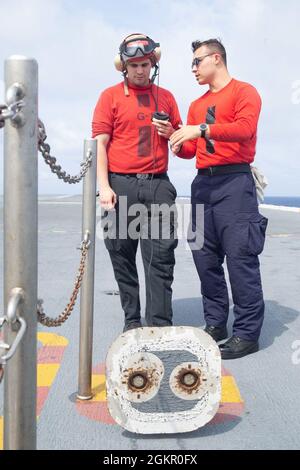 Aviation Ordnanceman Airman Kaeden Mathiesen, rechts, aus Manitowoc, Wisconsin, trainiert Aviation Ordnanceman Airman Aidyn Moller, aus Chicago, beide an die Waffenabteilung der USS Gerald R. Ford (CVN 78) auf der Flugdeck-Kontrollstation des Schiffes, 16. Juni 2021. Ford führt derzeit im Atlantik Full Ship Shock Trials (FSST) durch. Die US Navy führt Schockversuche an neuen Schiffsdesigns mit Live-Sprengstoffen durch, um zu bestätigen, dass unsere Kriegsschiffe auch unter den harten Bedingungen, die sie im Kampf treffen könnten, weiterhin anspruchsvolle Missionsanforderungen erfüllen können. Stockfoto