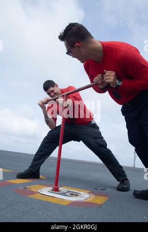 Aviation Ordnanceman Airman Aidyn Moller, links, aus Chicago, und Aviation Ordnanceman Airman Kaeden Mathiesen, aus Manitowoc, Wisconsin, die beide der Waffenabteilung der USS Gerald R. Ford (CVN 78) zugeordnet sind, sichern die Flugdeck-Kontrollstation des Schiffes mit Advanced Weapons Elevator (AWE) und die schallbetriebene Telefonluke, 16. Juni 2021. Ford führt derzeit im Atlantik Full Ship Shock Trials (FSST) durch. Die US Navy führt Schockversuche an neuen Schiffsdesigns mit Live-Sprengstoffen durch, um zu bestätigen, dass unsere Kriegsschiffe auch weiterhin die anspruchsvollen Missionsanforderungen unter dem harten Bedingungen erfüllen können Stockfoto