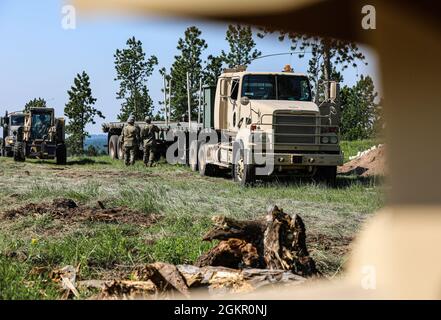 US-Soldaten des 152. Combat Sustainment Support Bataillons aus South Dakota, der 155. Engineer Company aus South Dakota und der 1644. Transformation Company aus Illinois bereiten sich auf die Timber Haul Übung während der Golden Coyote in Custer, S. D., 16. Juni 2021 vor. Die Golden Coyote-Übung ist eine dreiphasige, szenariogesteuerte Übung, die in den Black Hills von South Dakota und Wyoming durchgeführt wird und es den Kommandeuren ermöglicht, sich auf missionskritische Aufgabenanforderungen, Kriegeraufgaben und Kampfübungen zu konzentrieren. Stockfoto