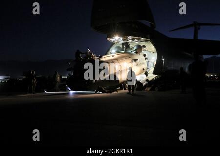 Antennenporteure arbeiten mit Betreuern zusammen, um einen CH-47 Chinook in einen C-17 Globemaster III zu laden, um die rückwirkende Mission Resolute Support in Afghanistan zu unterstützen, 16. Juni 2021. Stockfoto