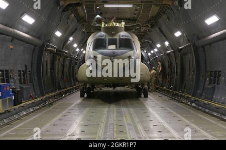 Antennenporteure arbeiten mit Betreuern zusammen, um einen CH-47 Chinook in einen C-17 Globemaster III zu laden, um die rückwirkende Mission Resolute Support in Afghanistan zu unterstützen, 16. Juni 2021. Stockfoto