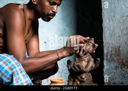 Konzentrieren Sie sich auf die Hände, konzentrierte Künstler machen Ton ganesh Idol für ganesha Festival - concpet der hinduistischen religiösen Festival Vorbereitungen in Indien. Stockfoto