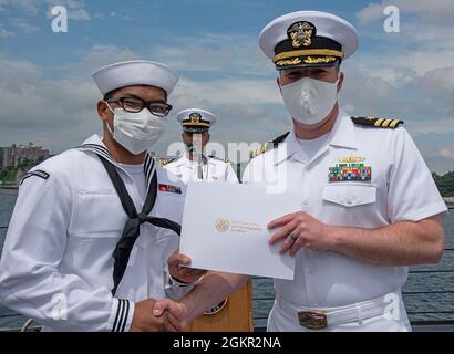 YOKOSUKA, Japan (17. Juni 2021) – Gasturbinen-Systemtechniker Mechanik 3. Klasse Patrick Luis Mendoza Abad, ein gebürtiger Philippiner, der an die USS Chancellorsville (CG 62) angeschlossen ist, erhält von Cmdr ein Staatsbürgerschaftszertifikat. Matthew Hays, Executive Officer der USS Milius (DDG 69), stationiert bei Commander, Fleet Activities Yokosuka (CFAY) während einer Einbürgerungszeremonie an Bord von Milius. Seit mehr als 75 Jahren stellt, pflegt und betreibt CFAY Basiseinrichtungen und -Dienste zur Unterstützung der vorbereitenden Seestreitkräfte der 7. US-Flotte, der Pächter-Kommandos und Tausender von Militärs Stockfoto