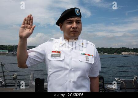 YOKOSUKA, Japan (17. Juni 2021) – SPC der US-Armee. Rigoberto Montoya Arcega, ein gebürtiger Mexikaner, der der medizinischen Abteilung Activity Japan im Camp Zama angeschlossen ist, rezitiert den Treueeid während einer Einbürgerungszeremonie an Bord des Arleigh Burke-Klasse Aegis Lenkrakenzerstörers USS Milius (DDG 69), der beim Commander, Fleet Activities Yokosuka (CFAY) stationiert ist. Seit mehr als 75 Jahren bietet, pflegt und betreibt CFAY Basiseinrichtungen und -Dienste zur Unterstützung der im Vorlauf eingesetzten Seestreitkräfte der US-amerikanischen 7. Flotte, der Pächter-Kommandos und tausender militärischer und ziviler Mitarbeiter sowie der Stockfoto