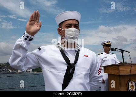 YOKOSUKA, Japan (17. Juni 2021) – der Feuerwehrmann Carl Jefferson Robles Dela Cruz, ein gebürtiger Philippiner, der an den Aegis-Lenkflugkörper-Zerstörer USS Milius (DDG 69) der Arleigh Burke-Klasse angeschlossen ist, rezitiert während einer Einbürgerungszeremonie an Bord von Milius, der im Commander, Fleet Activities Yokosuka (CFAY) stationiert ist, den Eid of Allegiance. Seit mehr als 75 Jahren stellt, pflegt und betreibt CFAY Basiseinrichtungen und -Dienste zur Unterstützung der im Einsatz kommenden Seestreitkräfte der 7. US-Flotte, der Pächter-Kommandos und Tausender militärischer und ziviler Mitarbeiter und ihrer Familien. Stockfoto