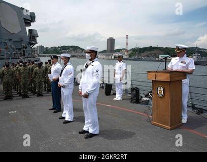 YOKOSUKA, Japan (17. Juni 2021) – Cmdr. Matthew Hays, rechts, Executive Officer der Arleigh Burke-Klasse, Aegis Lenkflugkörper-Zerstörer USS Milius (DDG 69) stationiert bei Commander, Fleet Activities Yokosuka (CFAY) spricht drei neue amerikanische Bürger während einer Einbürgerungszeremonie an Bord von Milius, stationiert bei Commander, Fleet Activities Yokosuka (CFAY). Zwei Matrosen, Gasturbinen-Systemtechniker mechanisch 3. Klasse Patrick Luis Mendoza Abad, ein gebürtiger Philippiner, der an die USS Chancellorsville (CG 62) angeschlossen ist, Feuerwehrmann Carl Jefferson Robles Dela Cruz, ein gebürtiger Philippiner attache Stockfoto