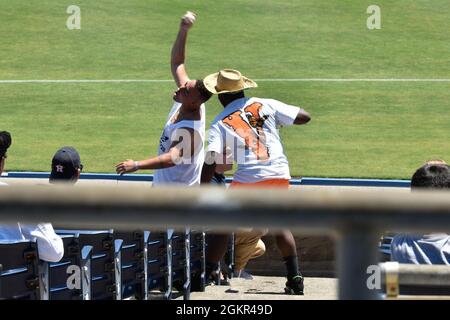 US Navy Boatswain Mate 3rd Class Jerron Johnson aus New Orleans fängt bei einem Baseballspiel der Norfolk Tides im Harbor Park für eine von Moral, Welfare and Recreation gesponserte Veranstaltung am 17. Juni 2021 in Norfolk, Virginia, einen streunenden Baseballschläger ein. Die John C. Stennis (CVN 74) arbeitet in der Newport News Shipyard zusammen mit NNS, NAVSEA und Auftragnehmern, die die Betankung von Komplexüberholungen durchführen, um das Kriegsschiff rechtzeitig und im Rahmen des Budgets wieder in den Kampf zu bringen, um seine Pflicht zur Verteidigung der Vereinigten Staaten wiederaufzunehmen. Stockfoto