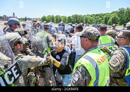 Mitglieder der Sicherheitskräfte der US-Luftwaffe in Zivilkleidung agieren als Demonstranten bei einer Massenkontrollübung, die zu simulierten Verhaftungen der zivilen Strafverfolgungsbehörden während DES PATRIOT 21 June 17, 2021 in Fort McCoy, Wisconsin, führt. PATRIOT 21 ist eine Trainingsübung, bei der Militärmitglieder auf die gleiche Weise wie bei einer Naturkatastrophe mit zivilem Notfallmanagement und Ersthelfern zusammenarbeiten können, damit im Falle einer realen Katastrophe alle Behörden ihre Reaktionsbemühungen maximieren können, Stellen Sie den betroffenen Gemeinden die erforderlichen Ressourcen zur Verfügung, und sparen Sie mehr Stockfoto