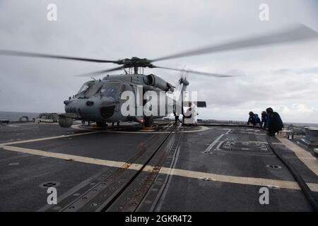 210617-N-CZ893-1271 PAZIFISCHER OZEAN (17. Juni 2021) Matrosen tanken einen MH-60S Sea Hawk, der dem Helicopter Sea Combat Squadron (HSC) 4 zugewiesen wurde, auf dem Flugdeck des Zerstörers USS Howard (DDG 83) der Arleigh Burke-Klasse, 17. Juni 2021. Howard führt derzeit routinemäßige Seeoperationen in der 3. Flotte der USA durch. Stockfoto