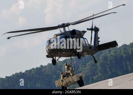 Marne Air-Soldaten, die dem 603rd Aviation Support Bataillon, der 3rd Combat Aviation Brigade, der 3rd Infantry Division, zugewiesen sind, bereiten sich darauf vor, einen Anhänger mit einem UH-60 Black Hawk-Hubschrauber während der Schleuderbelastung auf dem Hunter Army Airfield, Juni 17, anzuheben. Die Soldaten führten das Schlingentraining durch, um sich mit den Operationen vertraut zu machen und logistische Fähigkeiten erfolgreich per Flugzeug zu transportieren. Stockfoto