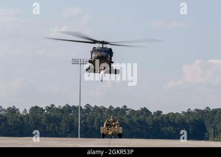 Marne Air-Soldaten, die dem 603. Aviation Support Bataillon, der 3. Combat Aviation Brigade, der 3. Infanterie-Division, zugewiesen sind, führen Schlingentraglasoperationen als Teil des „Hook-up“-Teams im Hunter Army Airfield, Juni 17, durch. Die Soldaten führten das Schlingentraining durch, um sich mit den Operationen vertraut zu machen und logistische Fähigkeiten erfolgreich per Flugzeug zu transportieren. Stockfoto