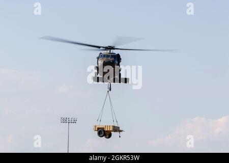 Marne Air-Soldaten, die dem 603rd Aviation Support Bataillon, der 3rd Combat Aviation Brigade, der 3rd Infantry Division, zugewiesen sind, verwenden einen UH-60 Black Hawk-Hubschrauber, um während der Schleuderbelastung auf dem Hunter Army Airfield, Juni 17, einen Anhänger zu heben. Die Soldaten führten das Schlingentraining durch, um sich mit den Operationen vertraut zu machen und logistische Fähigkeiten erfolgreich per Flugzeug zu transportieren. Stockfoto