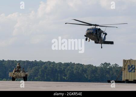 Marne Air-Soldaten, die dem 603. Aviation Support Bataillon, der 3. Combat Aviation Brigade, der 3. Infanterie-Division, zugewiesen sind, führen Schlingentraglasoperationen als Teil des „Hook-up“-Teams im Hunter Army Airfield, Juni 17, durch. Die Soldaten führten das Schlingentraining durch, um sich mit den Operationen vertraut zu machen und logistische Fähigkeiten erfolgreich per Flugzeug zu transportieren. Stockfoto