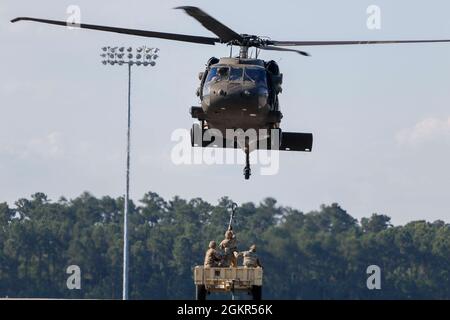 Marne Air-Soldaten, die dem 603. Aviation Support Bataillon, der 3. Combat Aviation Brigade, der 3. Infanterie-Division, zugewiesen sind, führen Schlingentraglasoperationen als Teil des „Hook-up“-Teams im Hunter Army Airfield, Juni 17, durch. Die Soldaten führten das Schlingentraining durch, um sich mit den Operationen vertraut zu machen und logistische Fähigkeiten erfolgreich per Flugzeug zu transportieren. Stockfoto